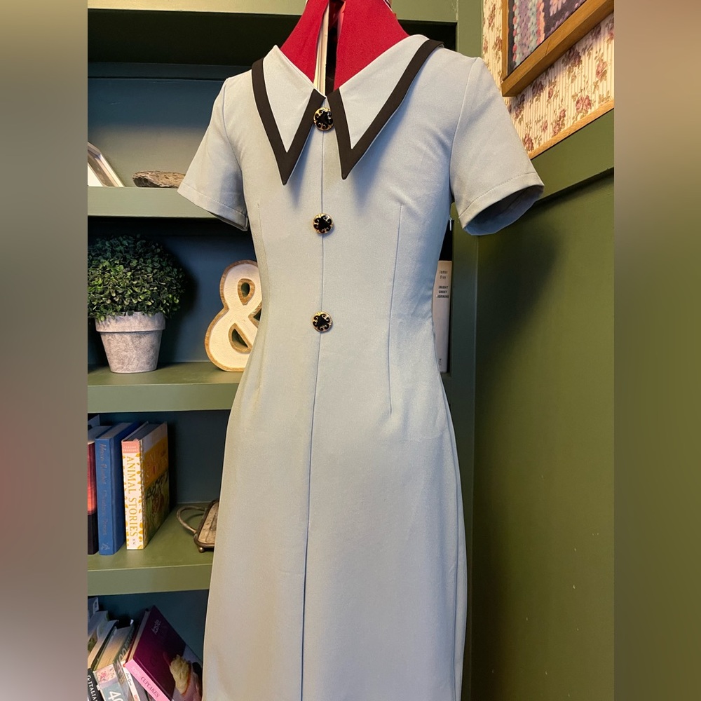 Pale blue dress with sharp black collars and decorative buttons